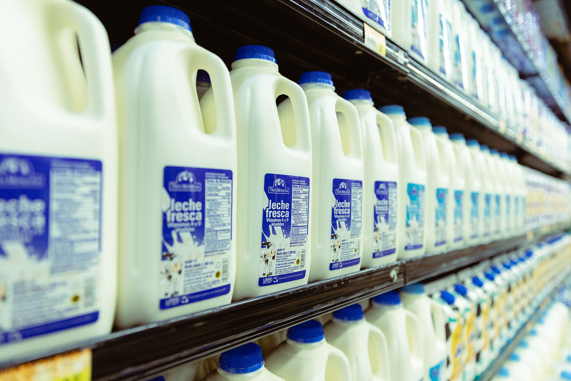 Leche fresca Tres Monjitas en varias presentaciones en la nevera de un supermercado