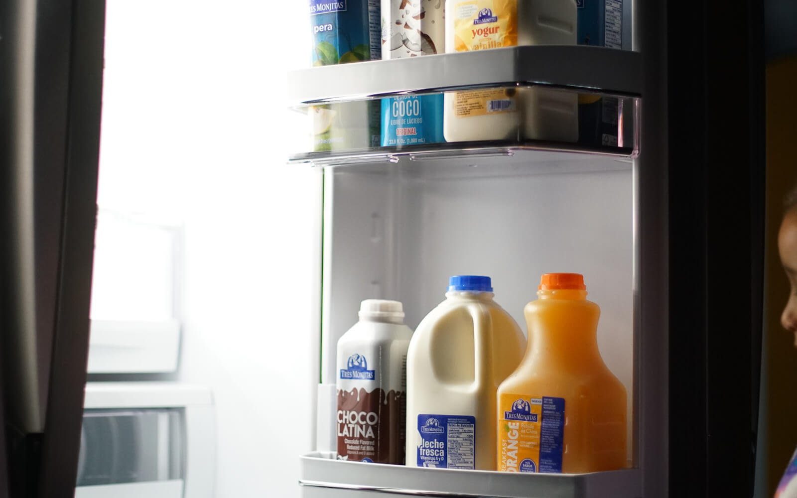 La puerta de una nevera con chocolatina, leche fresca, yogur, leche de coco, breakfast orange y néctar Tres Monjitas