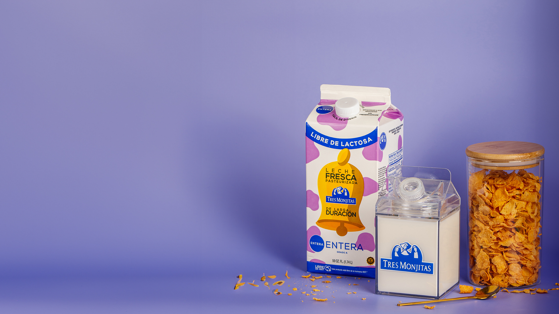 Bote de leche fresca de larga duración entera Tres Monjitas con un frasco lleno de cereal de hojuelas de maiz