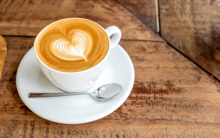 Una taza de café con leche Tres Monjitas y un diseño de corazón realizado por el barista.